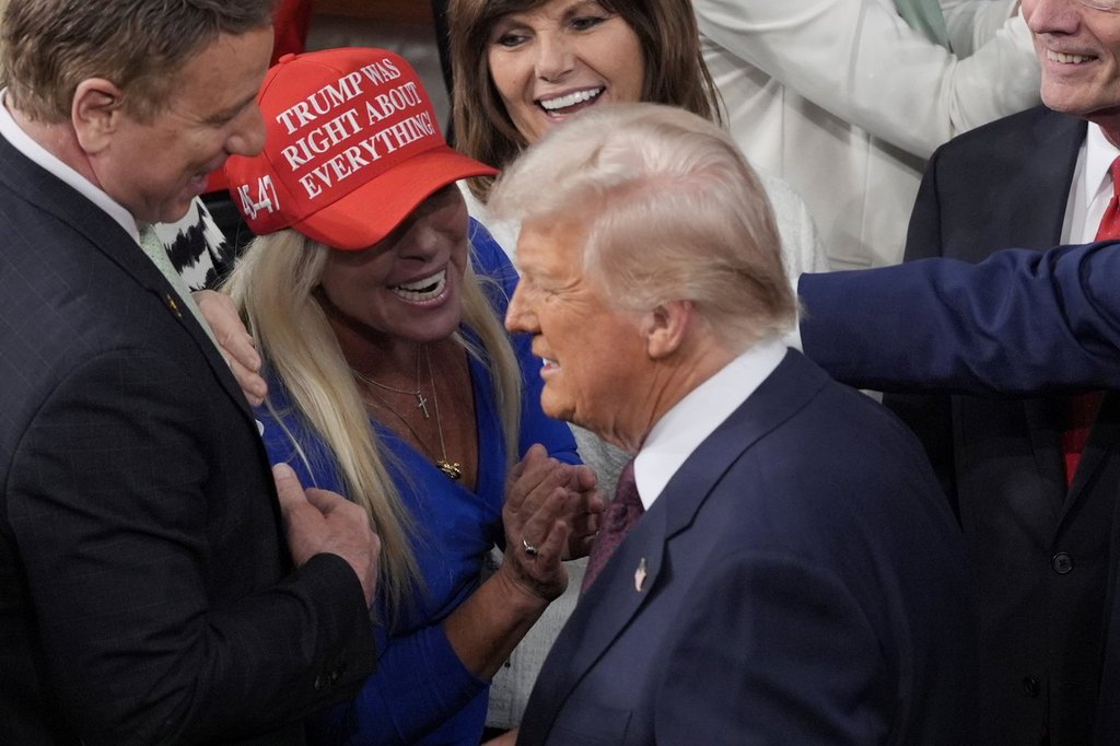 FILE - President Donald Trump arrives and walks by Rep. Marjorie Taylor Greene, R-Ga., to address a joint session of Congress at the Capitol in Washington, Tuesday, March 4, 2025.