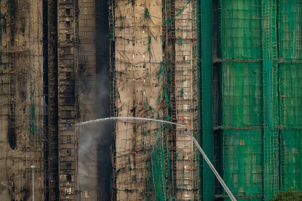 Firefighters work to extinguish a fire which broke out Wednesday at Wang Fuk Court, a residential estate in the Tai Po district of Hong Kong's New Territories, Thursday, Nov. 27, 2025.
