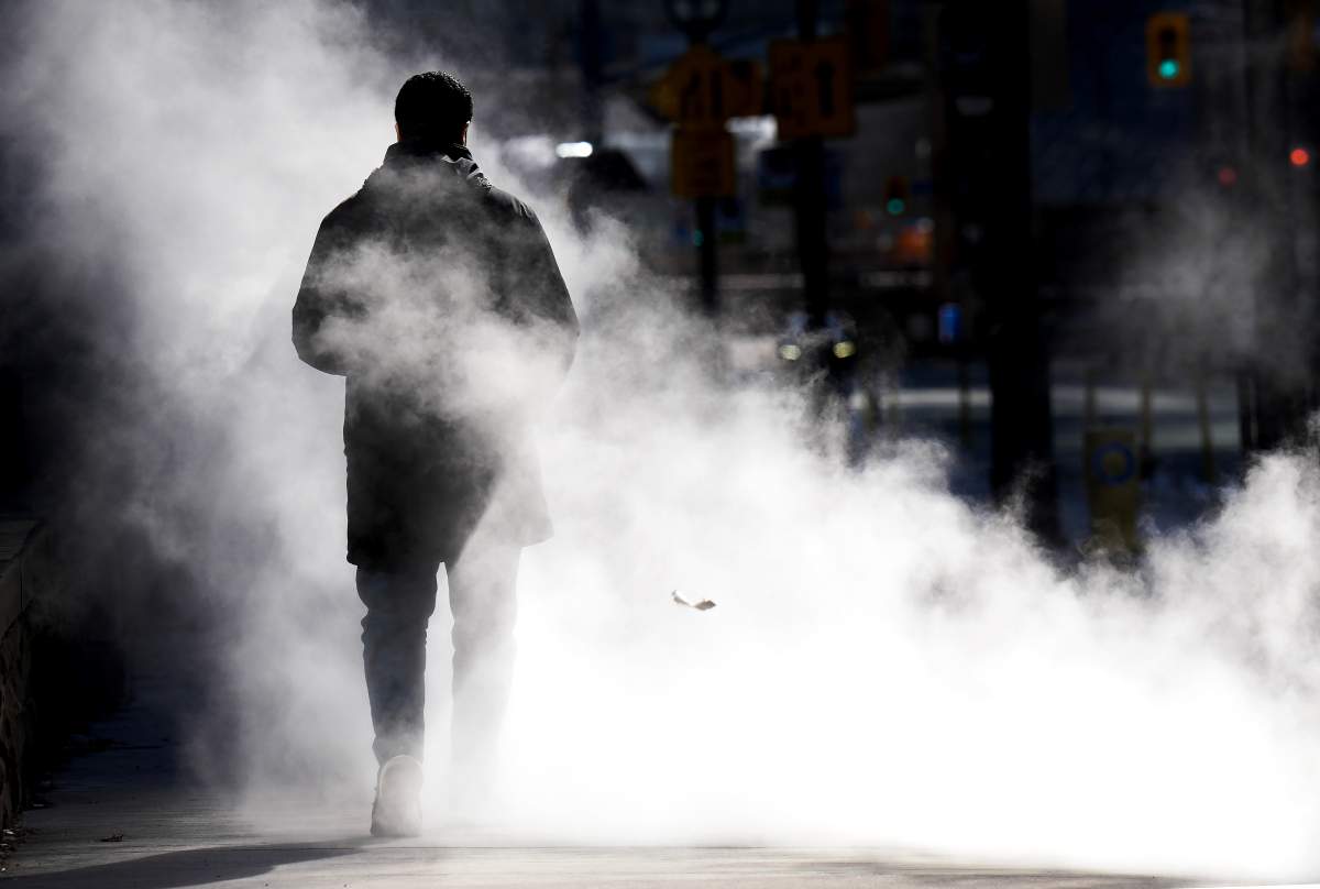 A man walks through steam in the cold winter weather in Toronto on Feb. 3, 2023. Most of Ontario is under an extreme cold warning as a blast of arctic air delivers biting wind chills. Environment Canada is warning of wind chill values between -30 C and -40 C across much of southern and eastern Ontario throughout Friday morning, which could cause frostbite to quickly develop on exposed skin.