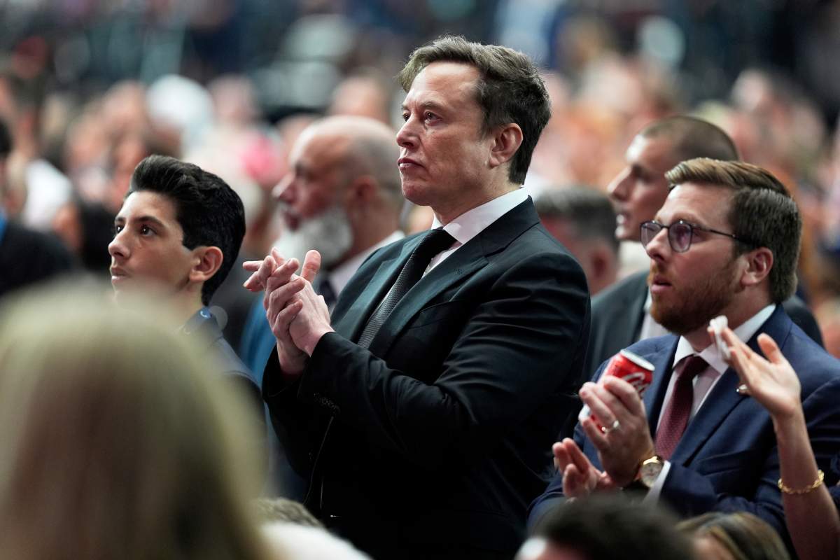 Elon Musk, center, claps during a memorial for conservative activist Charlie Kirk, Sunday, Sept. 21, 2025, at State Farm Stadium in Glendale, Ariz.