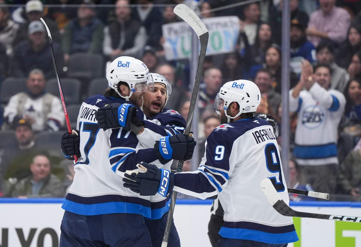 Winnipeg Jets' Adam Lowry, front left to right, Nino Niederreiter and Alex Iafallo celebrate Niederreiter's goal against the Vancouver Canucks during the first period of an NHL hockey game, in Vancouver, on Tuesday, November 11, 2025. THE CANADIAN PRESS/Darryl Dyck.
