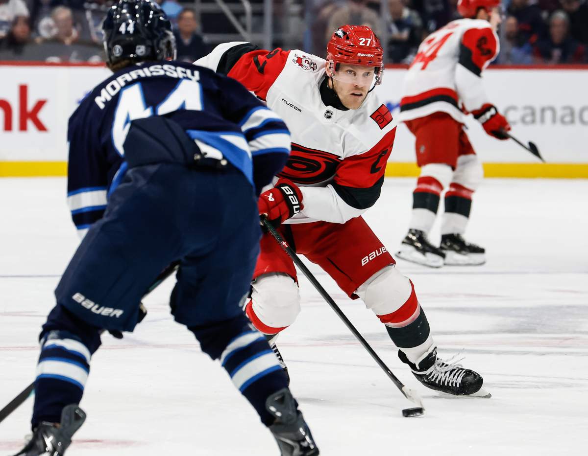 Carolina Hurricanes' Nikolaj Ehlers (27), formerly of the Winnipeg Jets, makes the pass against the Winnipeg Jets during first period NHL action in Winnipeg on Friday, November 21, 2025. THE CANADIAN PRESS/John Woods.