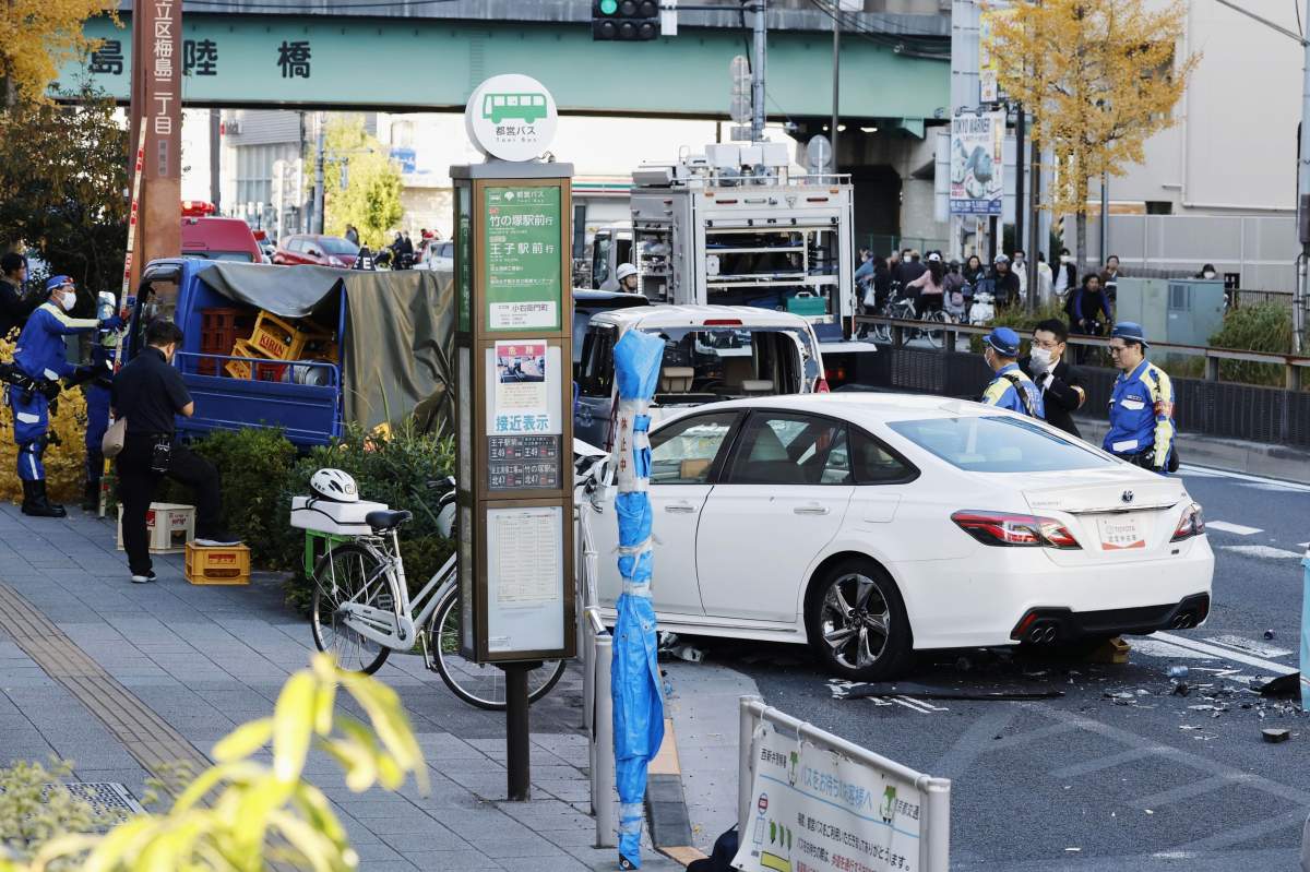 Investigators inspect the scene of a car accident injuring multiple people in Tokyo, Monday, Nov. 24, 2025. (Michi Ono/Kyodo News via AP).