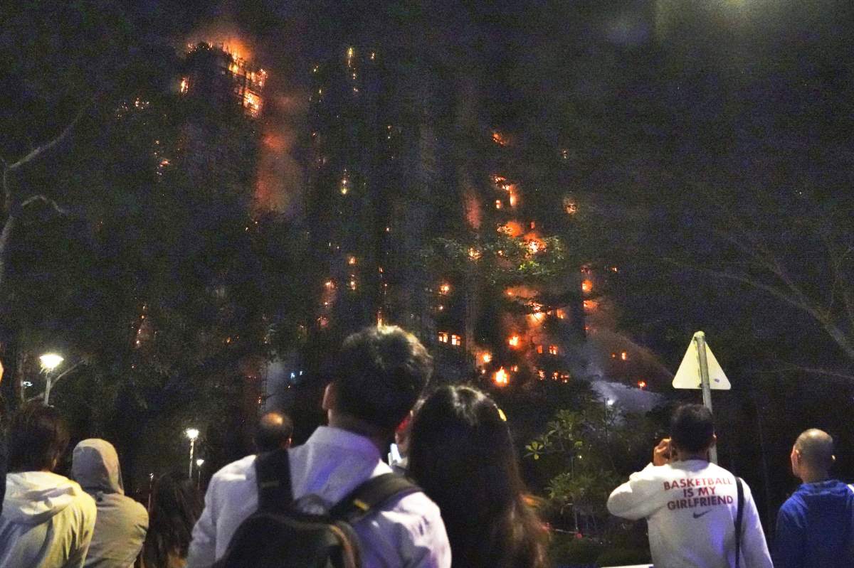 People look on as a massive fire engulfs a high-rise residential complex in the northern Tai Po district of Hong Kong on Nov. 26, 2025. The fire killed at least 44 people and left 45 in critical condition, with around 280 unaccounted for.