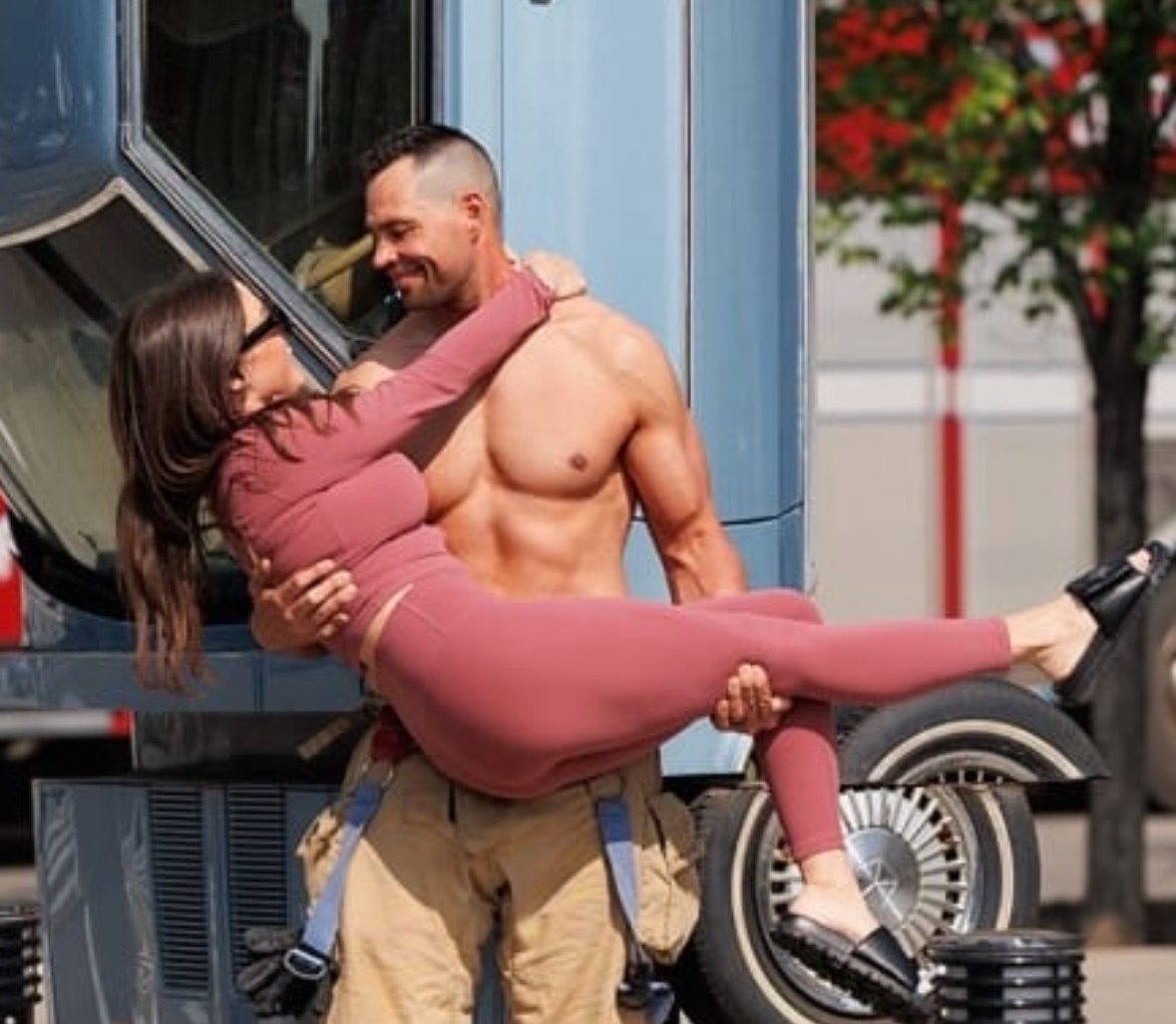 An Edmonton firefighter poses with his wife in front of a car