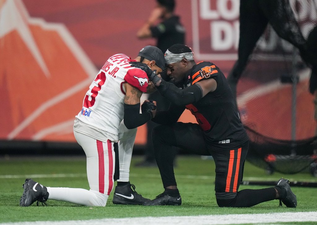 B.C. Lions' T.J. Lee, right, embraces Calgary Stampeders quarterback Vernon Adams Jr. after B.C. defeated Calgary during the CFL western semifinal football game, in Vancouver, on Saturday, November 1, 2025. THE CANADIAN PRESS/Darryl Dyck.