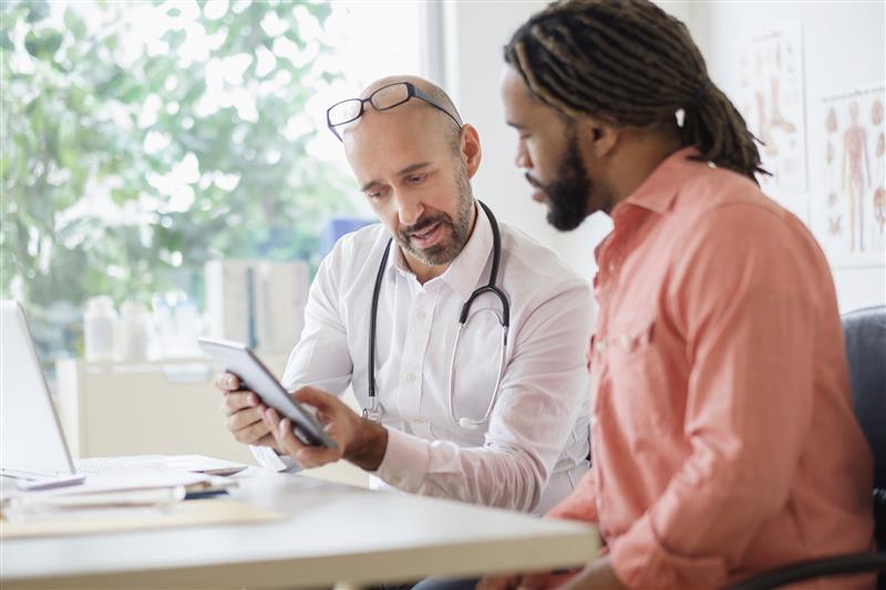 A doctor and their patient review medical information on a digital tablet. Tetra Images/Getty Images