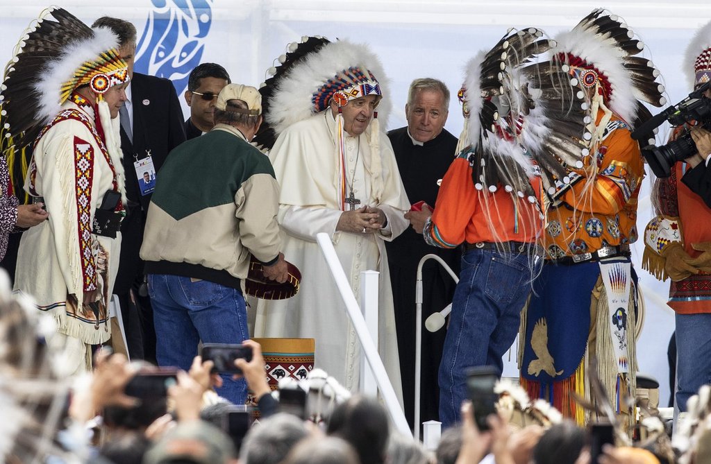 Pope Francis receives a traditional headdress after apologizing for the Roman Catholic Church’s role in the residential school system, in Maskwacis, Alta., during his papal visit across Canada on July 25, 2022.