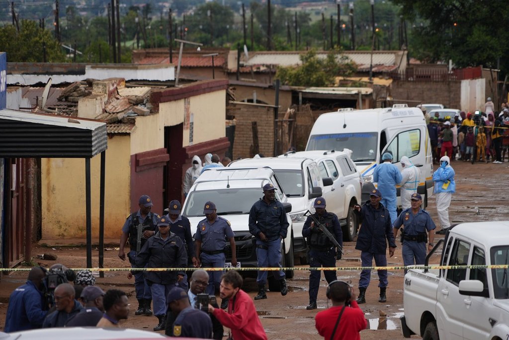 South African police gather at the scene of a fatal mass shooting at the KwaNoxolo Tavern in Bekkersdal, South Africa, Sunday, Dec. 21, 2025. (AP Photo/ Alfonso Nqunjana).