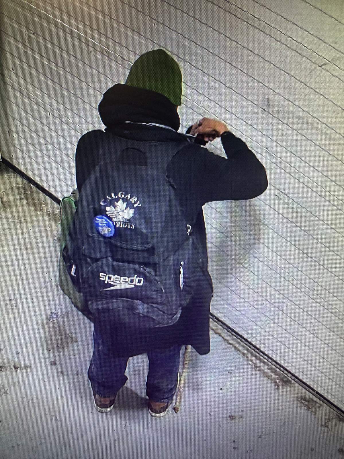 A suspect wearing a Speedo branded backpack