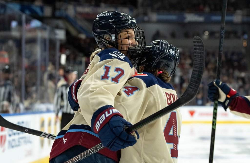 Montreal Victoire’s Dara Greig (17) and Amanda Boulier (44) celebrate Greig’s goal against the Vancouver Goldeneyes during the second period of a PWHL hockey game in Vancouver, B.C., Saturday, Dec. 20, 2025.