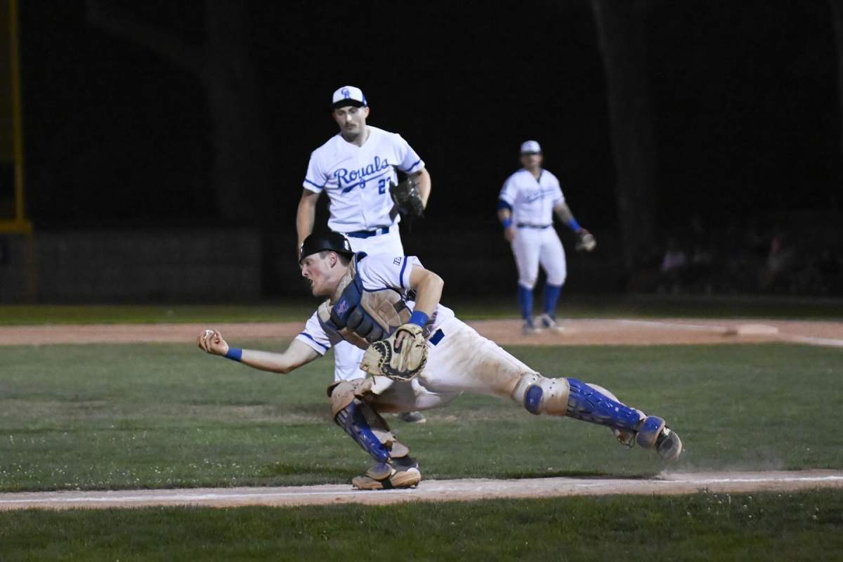 Guelph Royals catcher makes a diving play during a night game.