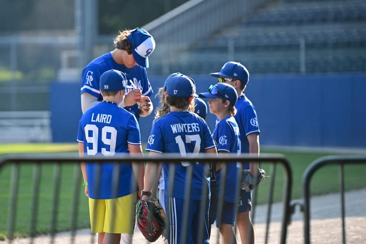 A Guelph Royals player signs autographs for young fans.