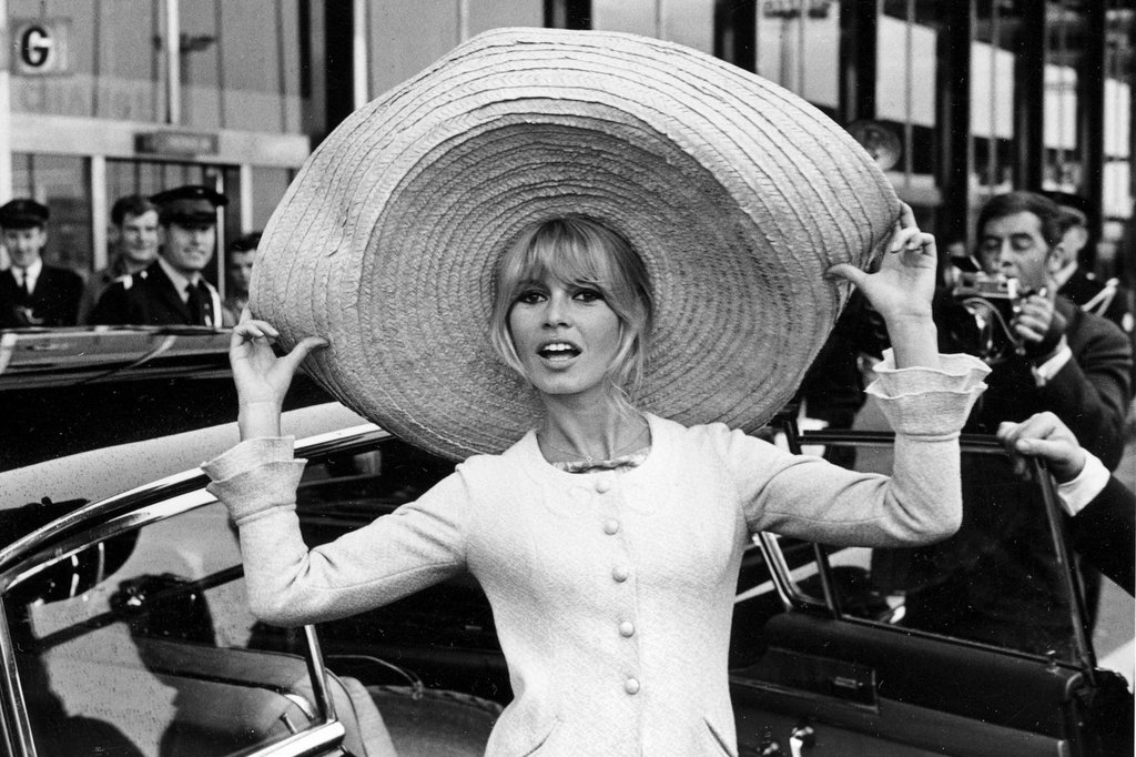 FILE - French actress Brigitte Bardot poses with a huge sombrero she brought back from Mexico, as she arrives at Orly Airport in Paris, France, on May 27, 1965.
