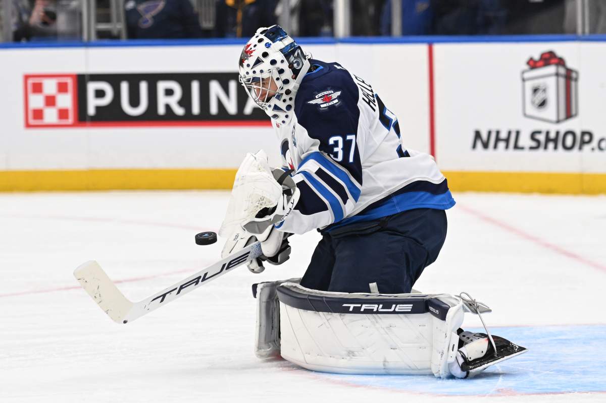 Winnipeg Jets goaltender Connor Hellebuyck (37) blocks a shot from the St. Louis Blues during the second period of an NHL hockey game on Wednesday, Dec. 17, 2025, in St. Louis. (AP Photo/Joe Puetz).