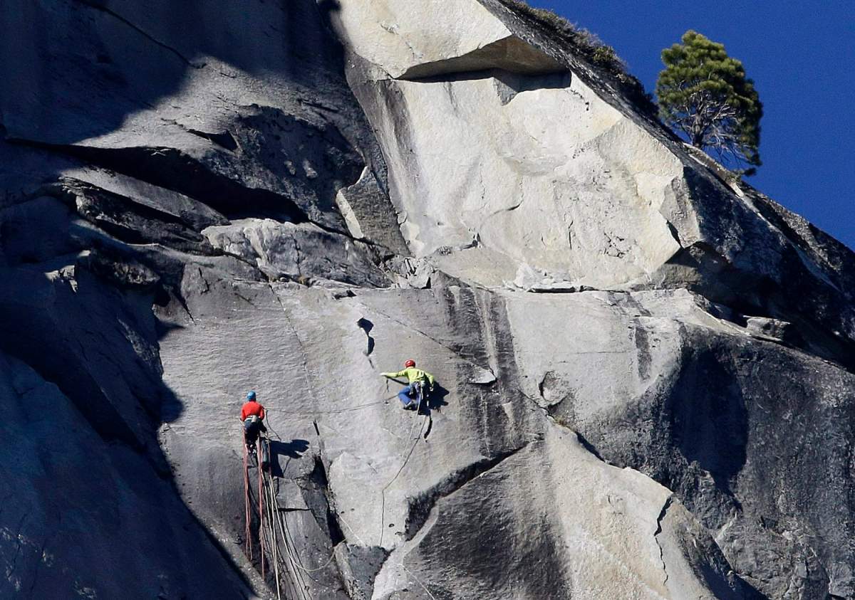 FILE - Kevin Jorgeson, left, and Tommy Caldwell climb El Capitan, Wednesday, Jan. 14, 2015, as seen from the valley floor in Yosemite National Park, Calif. Caldwell and Jorgeson became the first to free-climb the rock formation's Dawn Wall. They used ropes and safety harnesses to catch them in case of a fall, but relied entirely on their own strength and dexterity to ascend by grasping cracks as thin as razor blades and as small as dimes.