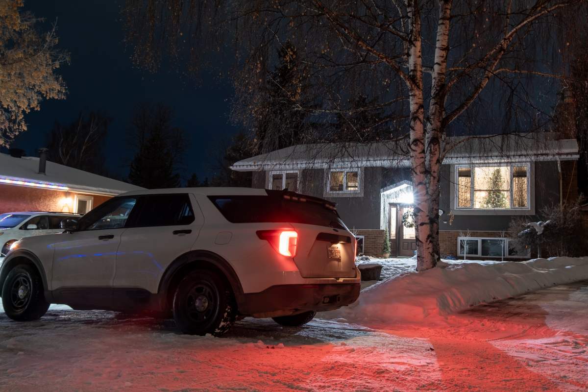 A white unmarked Calgary Police Service vehicle sits outside a house in Deer Run.