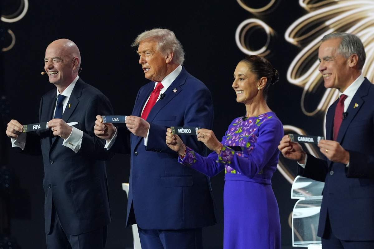 Prime Minister Mark Carney, Mexican President Claudia Sheinbaum, President Donald Trump and FIFA President Gianni Infantino hold up country names during the draw for the 2026 soccer World Cup at the Kennedy Center in Washington, Friday, Dec. 5, 2025.