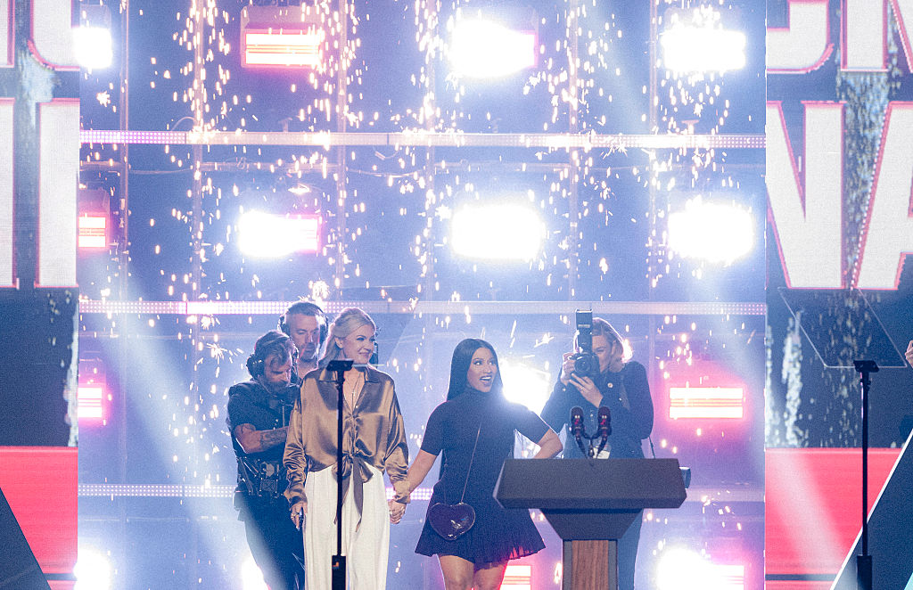 CEO and Chair of the Board of Turning Point USA Erika Kirk (L) and US rapper Nicki Minaj arrive on stage during Turning Point's annual AmericaFest conference in Phoenix, Arizona on December 21, 2025.