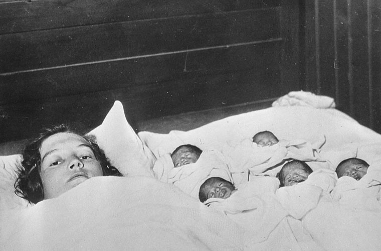Five Dionne babies with their mother in bed