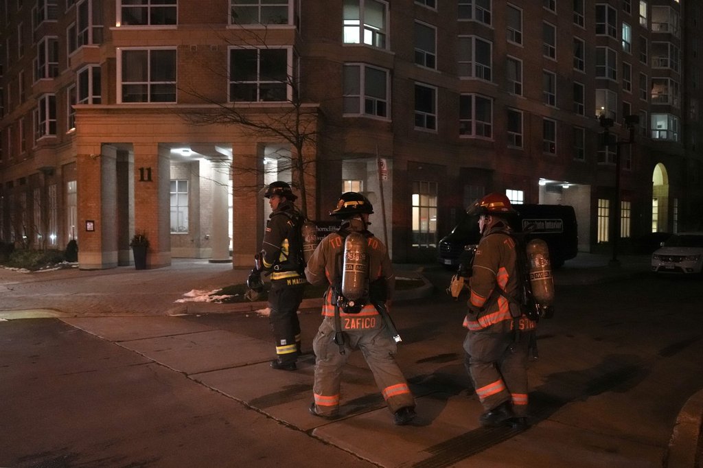 Members of the Fire Department walk towards a building in Thorncliffe Park in Toronto on Monday, Dec. 1, 2025. THE CANADIAN PRESS/Chris Young.