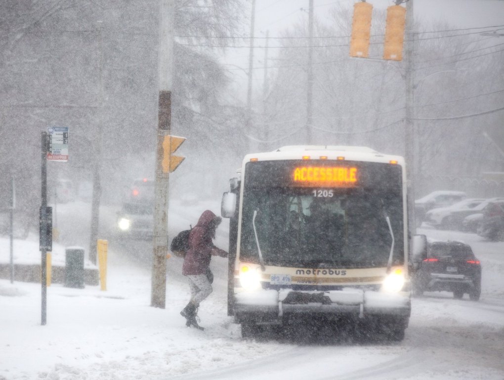 A commuter boards a public transit vehicle amid heavy snowfall in St. John's, Wednesday, Dec. 3, 2025. THE CANADIAN PRESS/Paul Daly.