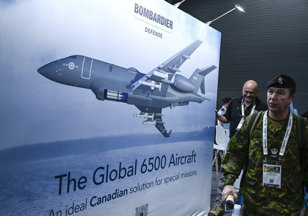 Attendees pass an image of the Bombardier Global 6500 Aircraft at the CANSEC trade show, billed as North America’s largest multi-service defence event, in Ottawa, on Wednesday, May 31, 2023. THE CANADIAN PRESS/Justin Tang.