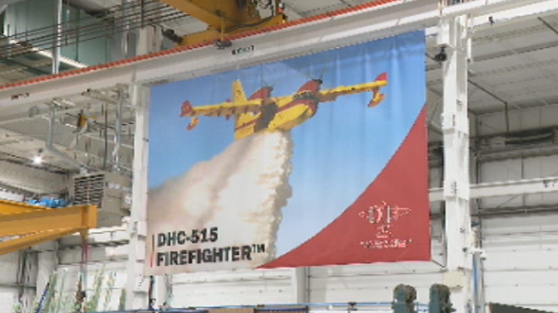 A banner of the firefighting aircraft CL-5151 hangs in a factory