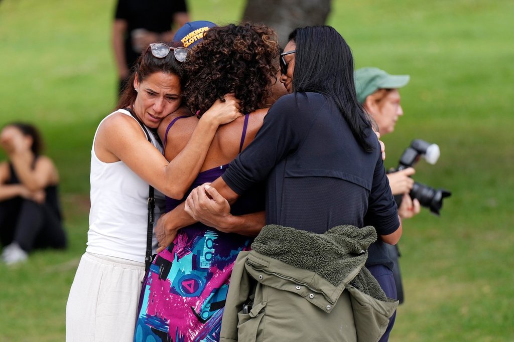Mourners embrace at a floral memorial placed outside Bondi Pavilion at Sydney’s Bondi Beach on Dec. 15, 2025, a day after a deadly shooting occurred.