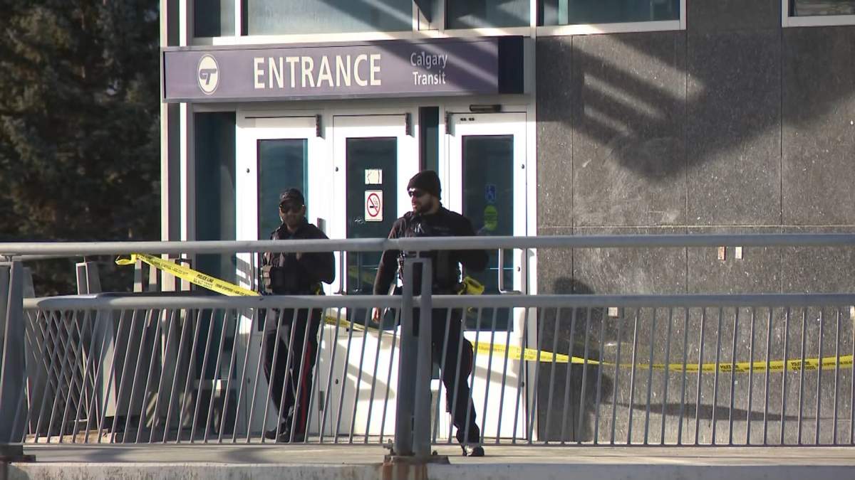 Calgary police officers stand guard at the Dalhousie LRT station on Tuesday after a man who allegedly had a knife was shot by police.