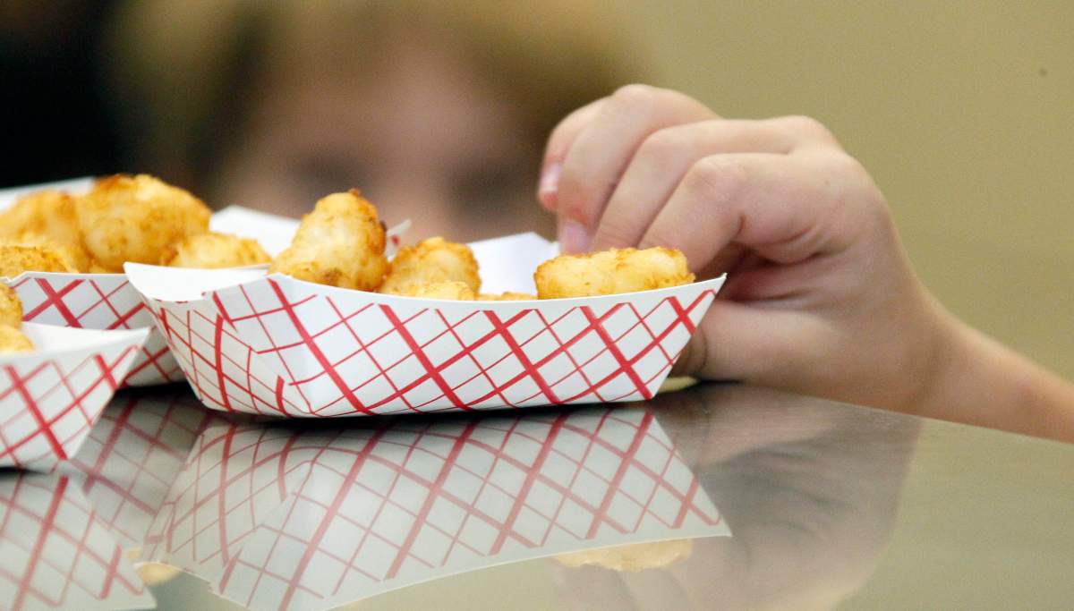 A tray of tater tots sits in a paper dish