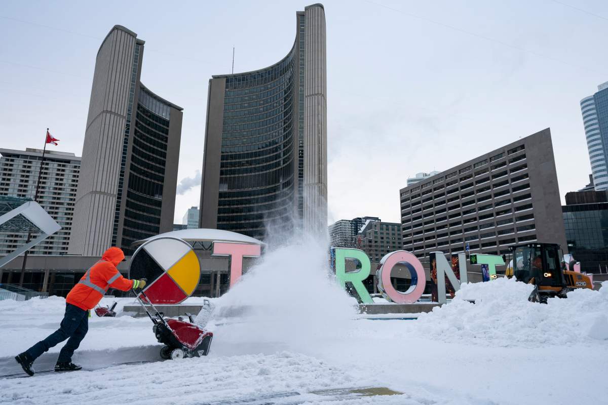 A worker uses a snowblower to clear snow from Nathan Phillips Square at city hall following a heavy snowfall in Toronto, on Thursday, Feb. 13, 2025.