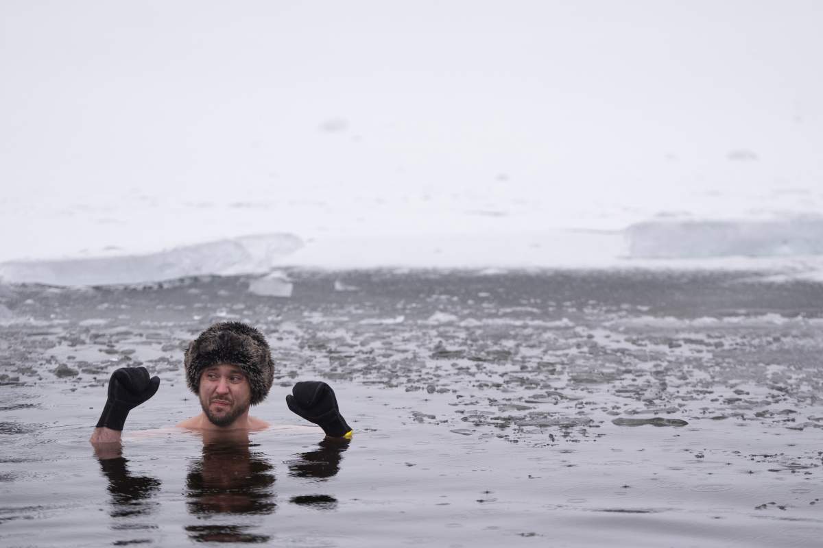 A person stays still in the ice-filled water in Lake Banook during the annual polar bear swim on New Year’s Day in Dartmouth, N.S., Thursday, Jan. 1, 2026. THE CANADIAN PRESS/Darren Calabrese