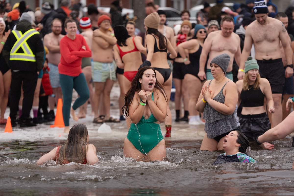 People react to entering the ice-filled water in Lake Banook during the annual polar bear swim on New Year’s Day in Dartmouth, N.S., Thursday, Jan. 1, 2026. THE CANADIAN PRESS/Darren Calabrese