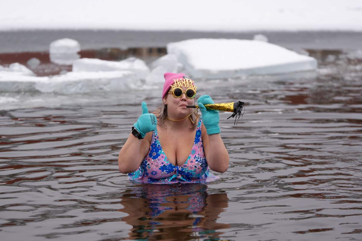 A person wears New Year's paraphernalia while swimming in the ice-filled water in Lake Banook during the annual polar bear swim on New Year's Day in Dartmouth, N.S., Thursday, Jan. 1, 2026. THE CANADIAN PRESS/Darren Calabrese.