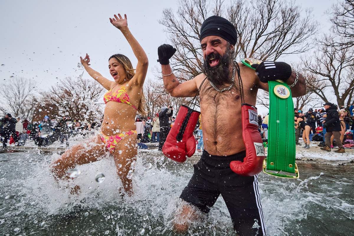Pardeep Singh Nagra, right, runs into the frigid water as he takes part in a New Year’s Day polar bear dip at Sunnyside beach in Toronto, on Thursday, Jan. 1, 2026. THE CANADIAN PRESS/Sammy Kogan