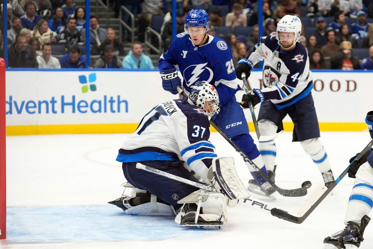 Winnipeg Jets goaltender Connor Hellebuyck (37) stops a shot by Tampa Bay Lightning right wing Pontus Holmberg (29) during the second period of an NHL hockey game Thursday, Jan. 29, 2026, in Tampa, Fla. (AP Photo/Chris O'Meara).