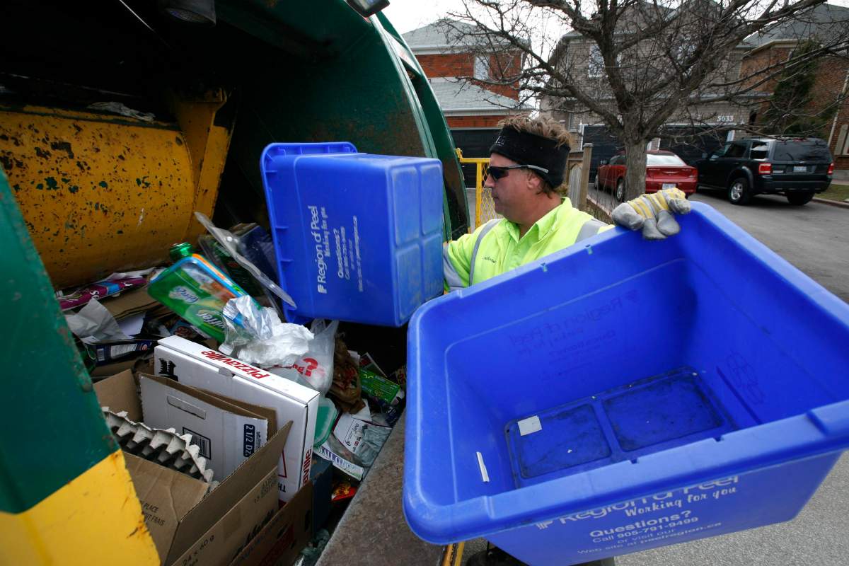 Mississauga, April 14/09 - Tony Owens, a Recycler with Waste Management, contracted out to the City of Mississauga collects recycling and organics on his route  off Erin Mills Parkway in Mississauga, Ontario Canada. The City of Mississauga will soon stop collecting juice boxes that have not been properly rinsed out and a collector will leave a sticker behind as to the reason why.
Photo .