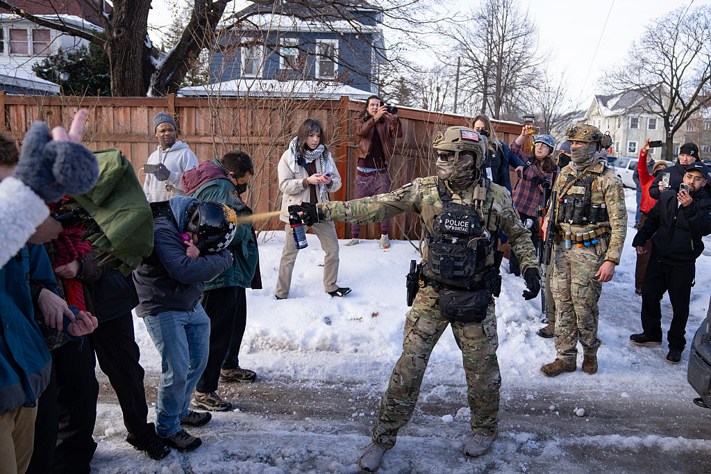 A Border Patrol Tactical Unit agent sprays pepper spray into the face of a protestor attempting to block an immigration officer vehicle from leaving the scene where a woman was shot and killed by a federal agent earlier, in Minneapolis, Minn. on Wednesday, January 7, 2026.