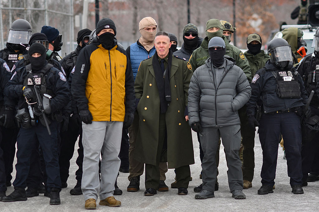 US Customs and Border Protection Commander Gregory Bovino (C) stands flanked by fellow federal agents during a protest against ICE outside the Bishop Whipple Federal Building in Minneapolis, Minnesota, on January 15, 2026.