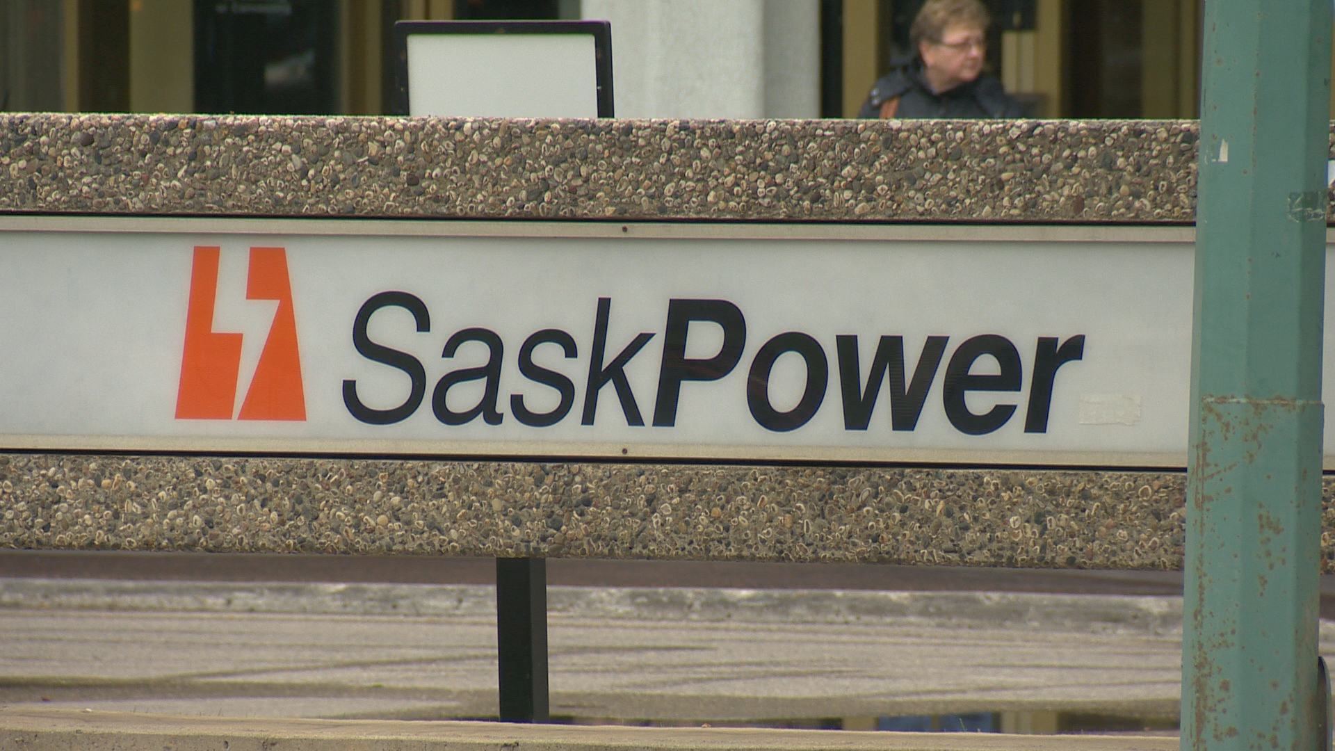 The SaskPower logo is placed on a white backdrop outside of its building in Regina.