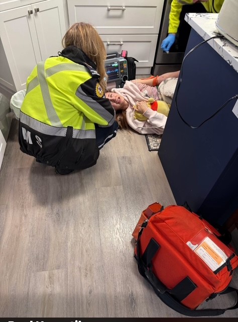 Talia Assu-Gregg, 20, being treated by EMS while in pain on the floor because of endometriosis.