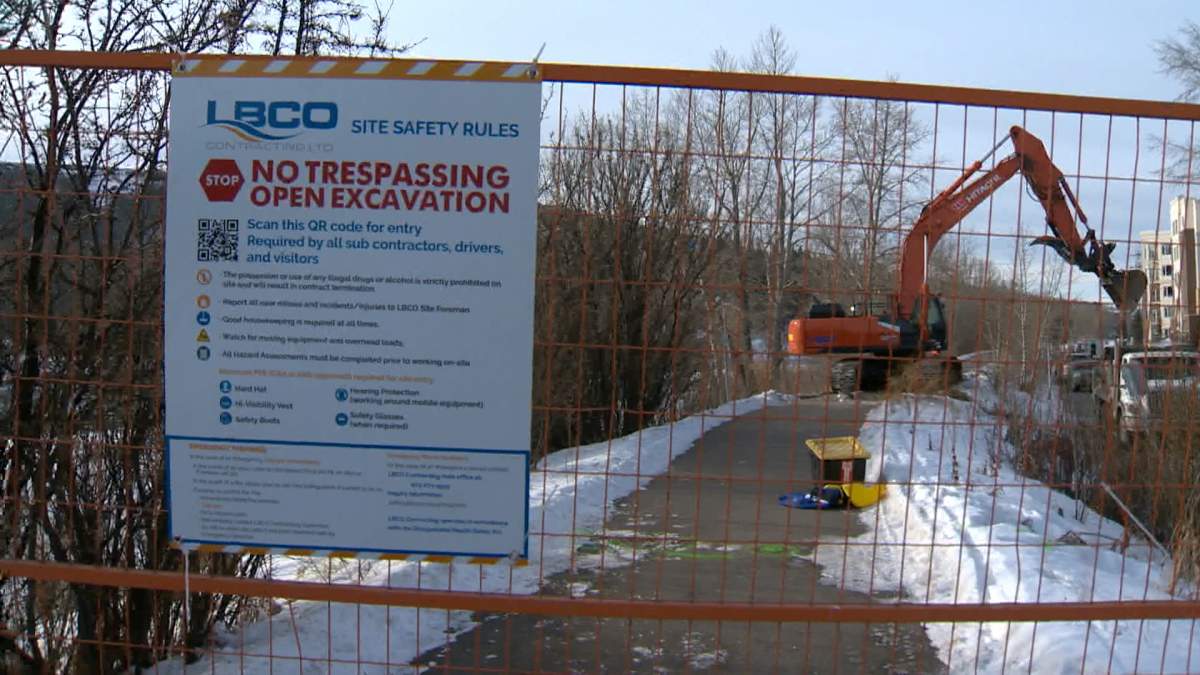 Part of the Bow River pathway is closed off as an excavator begins to dig out the flood barrier near Montgomery Blvd. SW on Friday.