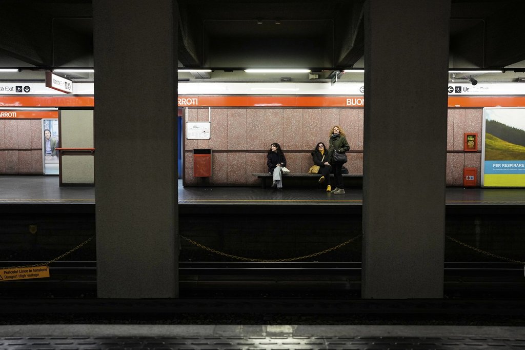 Women wait for the metro in Milan, Italy, Monday, Feb. 9, 2026. (AP Photo/Christophe Ena).