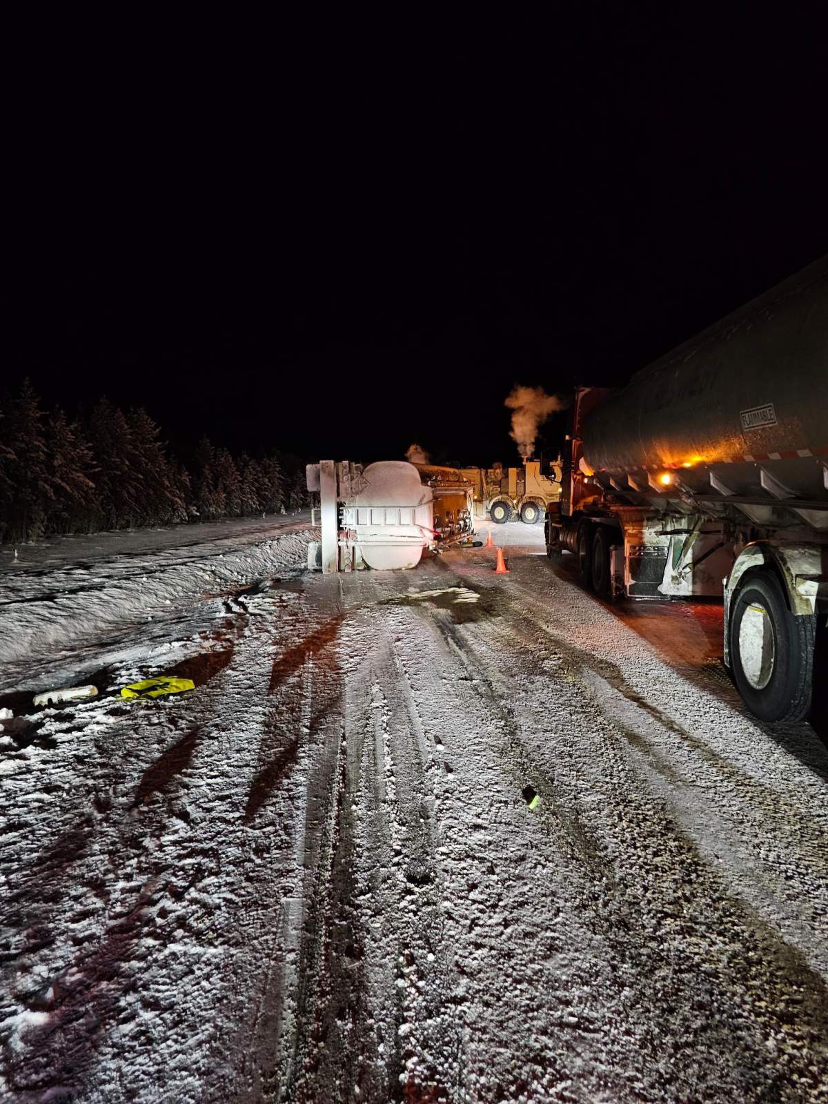 Canadian Armed Forces personnel examine the scene after a military fuel tanker filled with thousands of litres of diesel overturned on a highway near Kakisa, N.W.T. in this Monday, Feb. 9, 2026 handout photo.