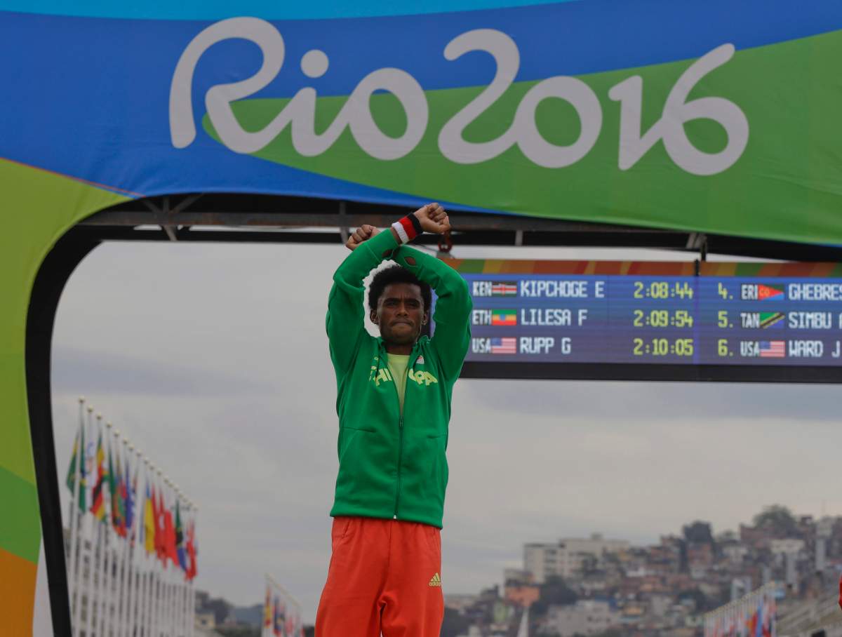 Feyisa Lilesa crosses arms on the Olympic podium