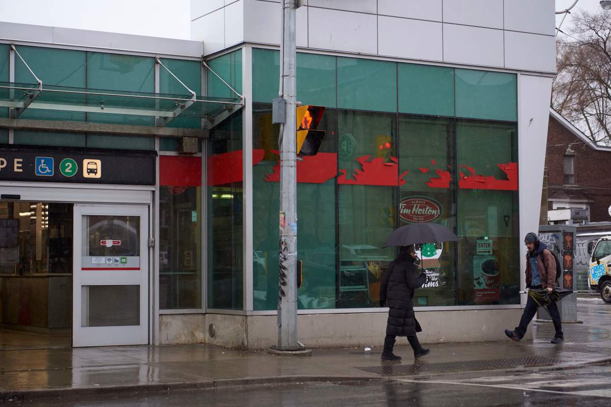 People walk past Pape station during a storm in Toronto on Dec. 15, 2022.