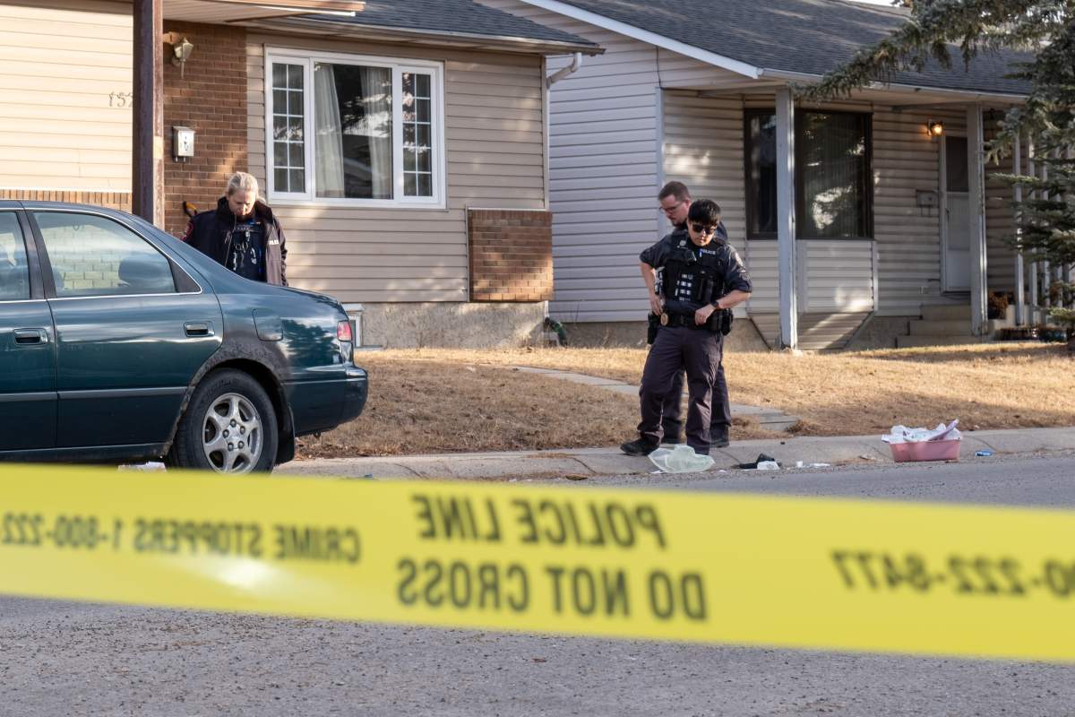 Police officers survey a scene of a serious assault