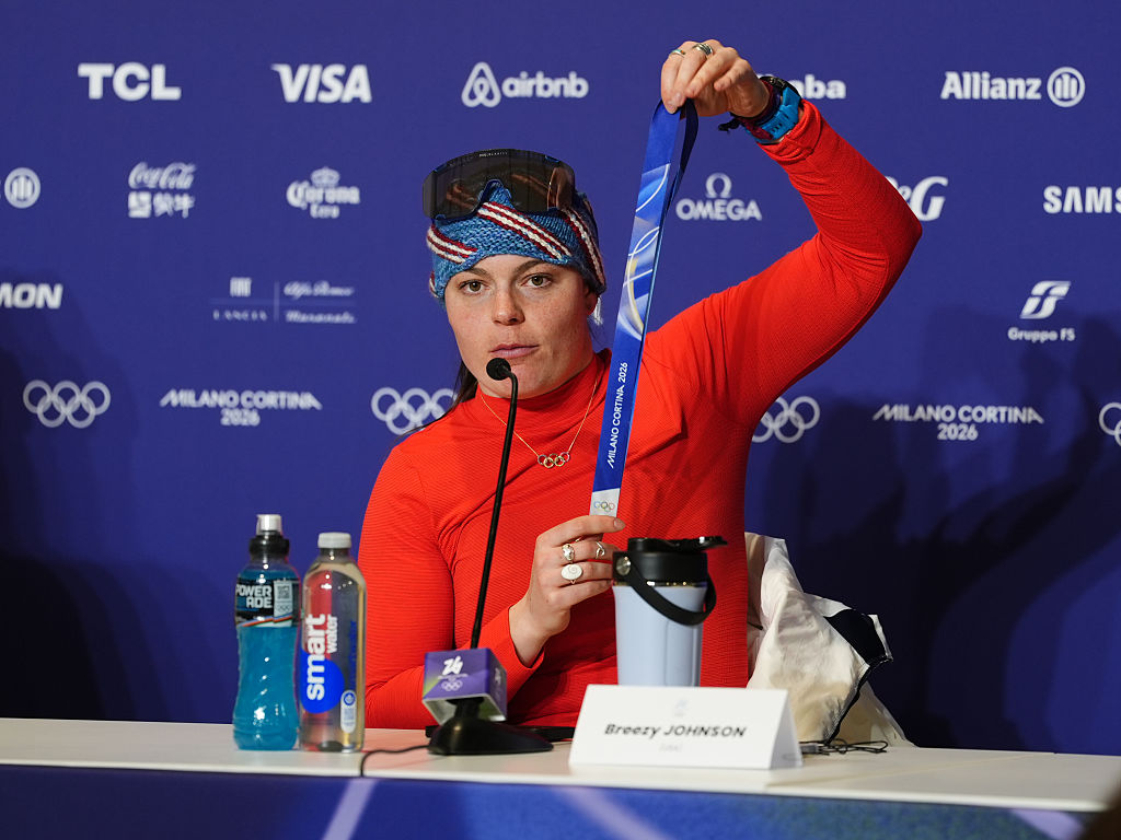 Gold medalist USA's Breezy Johnson shows her broken medal to the media following the Women's Alpine Downhill Skiing at the Tofane Alpine Skiing Centre, Cortina d'Ampezzo, on day two of the Milano Cortina 2026 Winter Olympics.