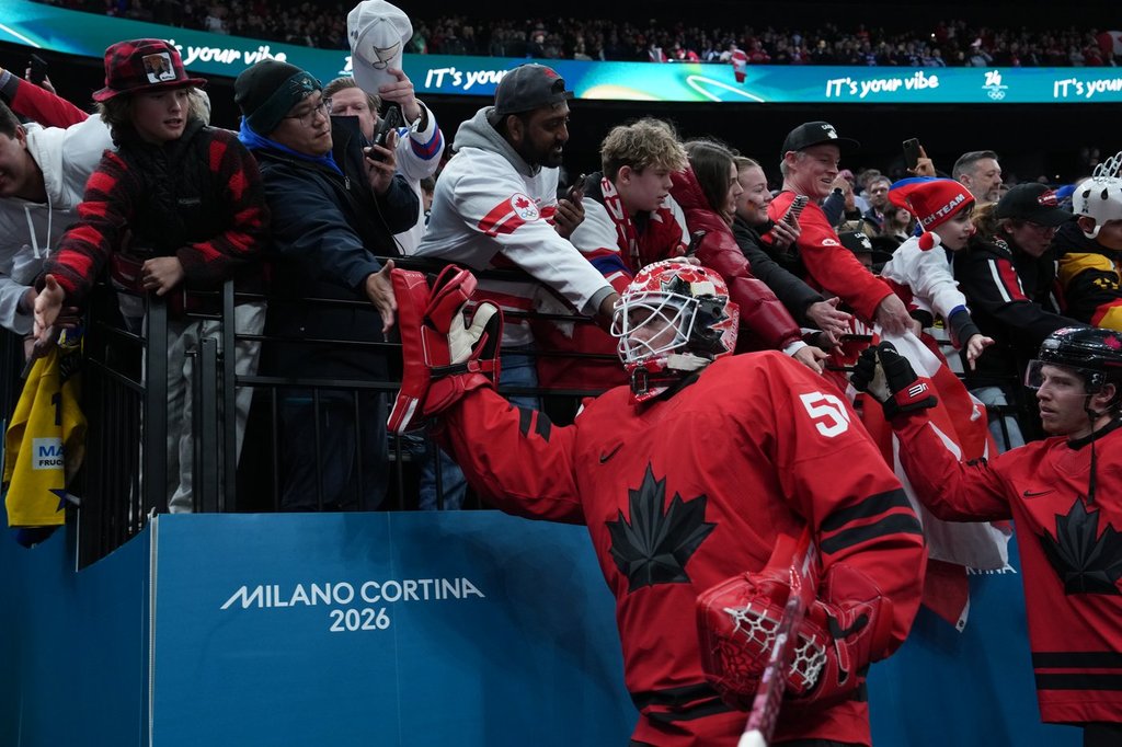 Canada goalie Jordan Binnington (50) and Mitch Marner (93) greet fans as they leave the ice after their overtime win against Czechia in a quarterfinal men's hockey game at the 2026 Winter Olympics, in Milan, on Wednesday, Feb. 18, 2026. THE CANADIAN PRESS/Darryl Dyck.